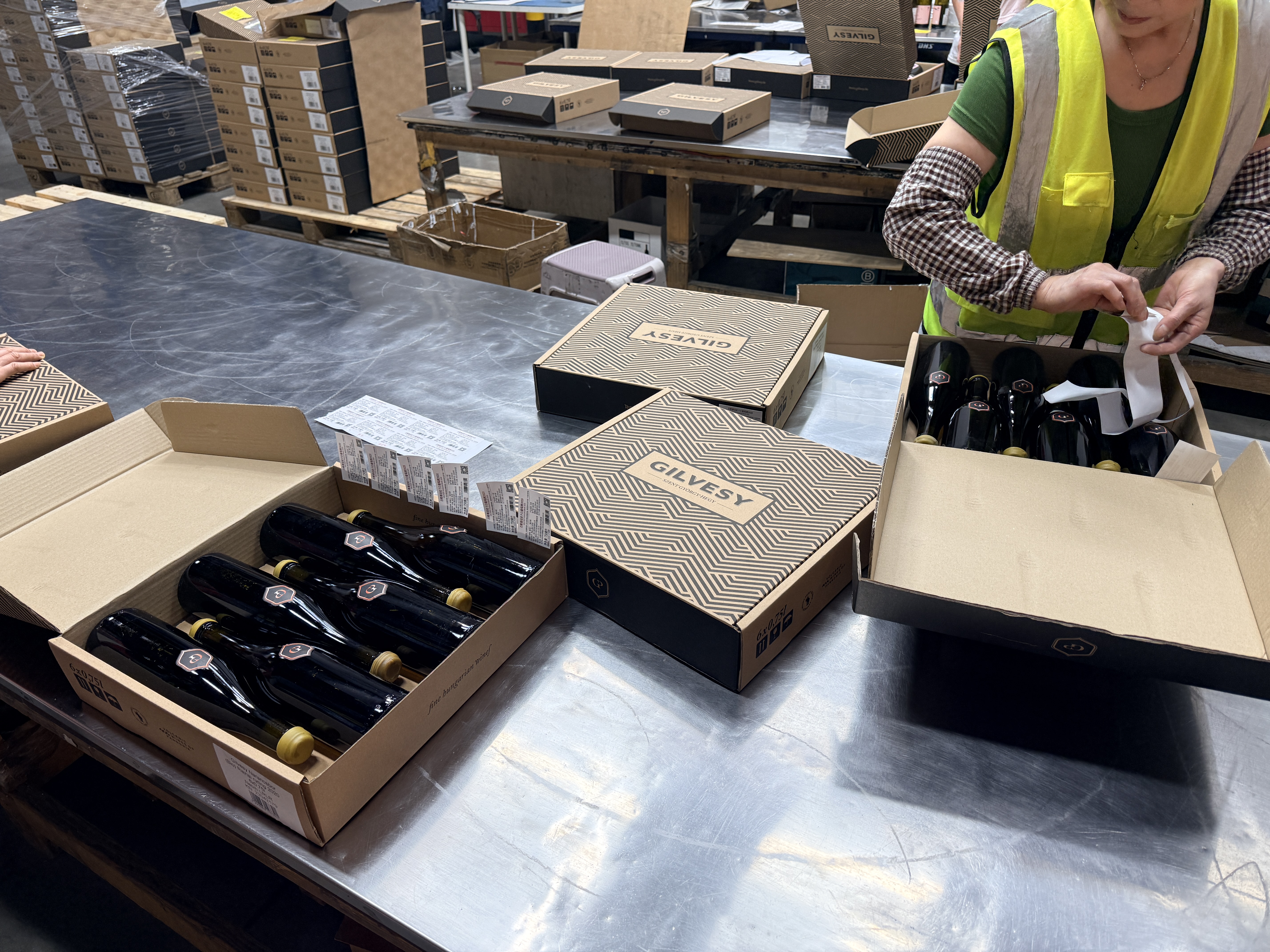 At the labelling table: open cases, bottles and labels ready for use.